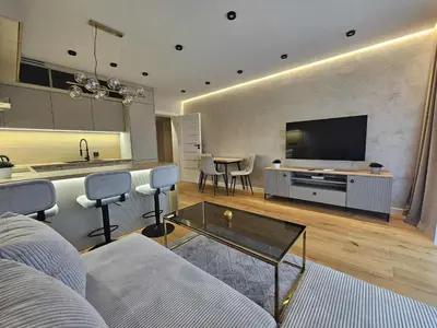 a living room with a couch and a tv and a table at DArt Apartments in Tomice