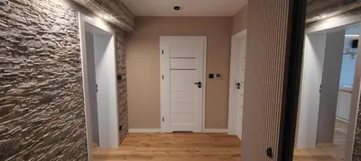 a hallway with a stone wall and a white door at DArt Apartments in Tomice