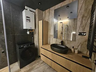 a bathroom with a sink and a washing machine at DArt Apartments in Tomice