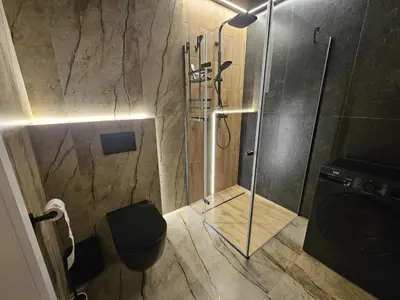 a bathroom with a shower with a toilet and a sink at DArt Apartments in Tomice