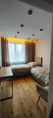 a bedroom with two beds and a table and a window at DArt Apartments in Tomice