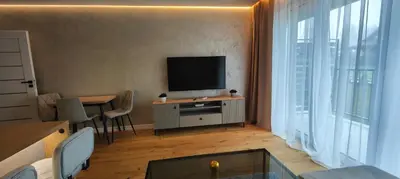 a living room with a television and a table with chairs at DArt Apartments in Tomice