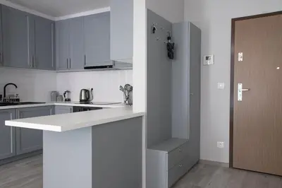 a bedroom with a bed and a window and a dresser at Cracow Modern Apartment FREE Parking, Views, Tram in Kraków