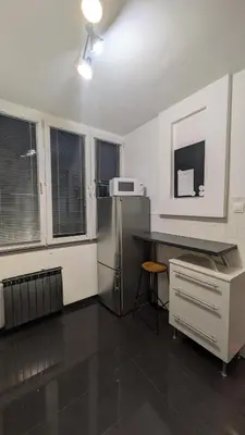 a kitchen with a refrigerator and a counter top at KrakowApart Dietla in Kraków