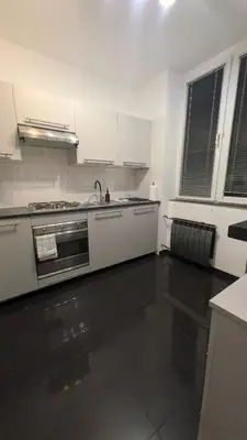 a white kitchen with a sink and a stove at KrakowApart Dietla in Kraków