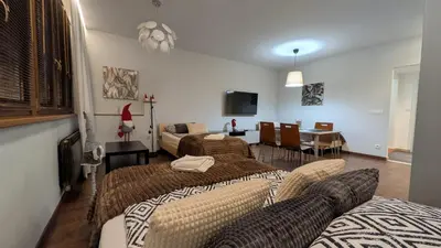 a room with two beds and a living room at KrakowApart Dietla in Kraków