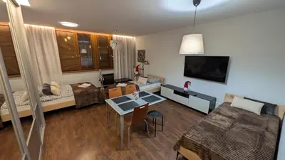 a living room with a bed and a dining room at KrakowApart Dietla in Kraków