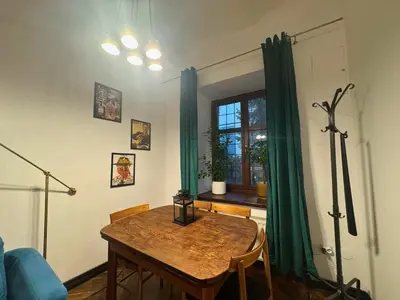 a dining room with a table and green curtains at Batory's Tavern in Kraków