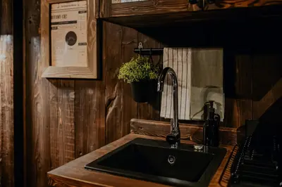 a kitchen with wooden cabinets and a counter in a room at Na Gorczańskim Wierchu Chalet, sauna i balia na wyłączność in Rabka