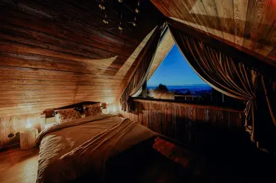 a bed with two green pillows and a wooden wall at Na Gorczańskim Wierchu Chalet, sauna i balia na wyłączność in Rabka