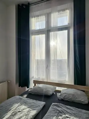 a bedroom with two beds and a window at W1 PRIVATE rooms in Kraków