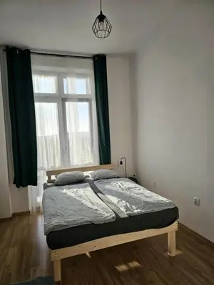 a bed in a room with a large window at W1 PRIVATE rooms in Kraków