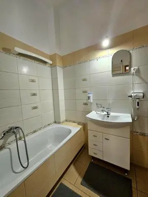 a bathroom with a bath tub and a sink at W1 PRIVATE rooms in Kraków