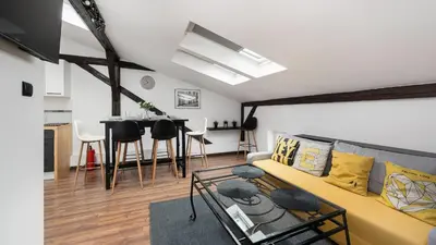 a living room with a yellow couch and a table at Sunshine Loft Cracow, Sun & Snow in Kraków