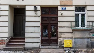 a door of a building with a sign in front of it at Sunshine Loft Cracow, Sun & Snow in Kraków