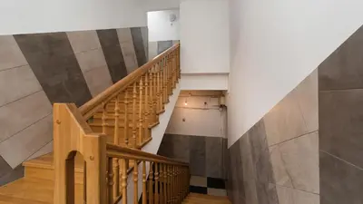 a staircase in a building with wooden railings at Sunshine Loft Cracow, Sun & Snow in Kraków