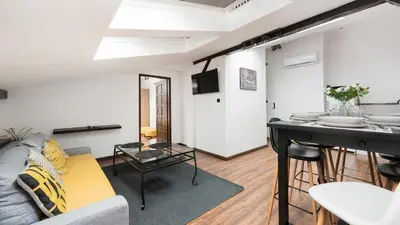 a living room with a couch and a table at Sunshine Loft Cracow, Sun & Snow in Kraków