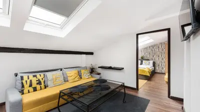 a living room with a yellow couch and a mirror at Sunshine Loft Cracow, Sun & Snow in Kraków