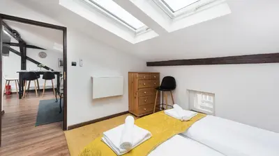 a bedroom with a bed and a mirror at Sunshine Loft Cracow, Sun & Snow in Kraków