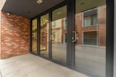 an entrance to a brick building with sliding glass doors at Kraków Główny Comfort Studio by BookingHost in Kraków