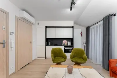 a living room with two green chairs and a couch at Kraków Główny Comfort Studio by BookingHost in Kraków