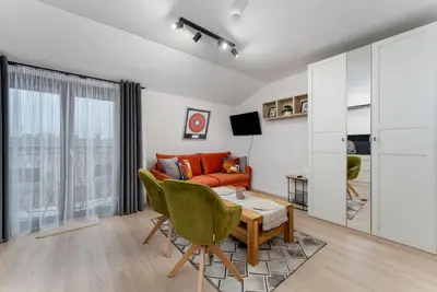 a living room with a couch and a table at Kraków Główny Comfort Studio by BookingHost in Kraków