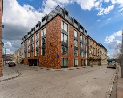 a red brick building on the side of a street at Kraków Główny Comfort Studio by BookingHost in Kraków