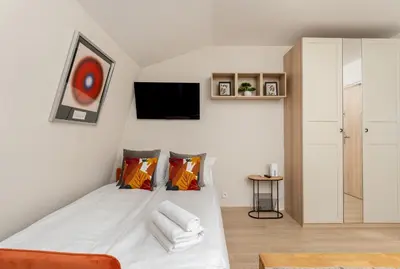 a bedroom with a bed and a tv on the wall at Kraków Główny Comfort Studio by BookingHost in Kraków