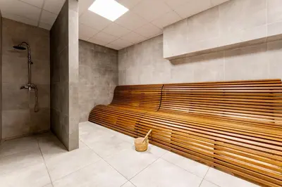 a large wooden bench in a bathroom with a shower at Kraków Główny Comfort Studio by BookingHost in Kraków