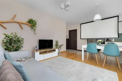 a living room with a couch and a large screen at Family Apartment in Cracow with Parking, Desk and Bathtub by Noclegi Renters in Kraków