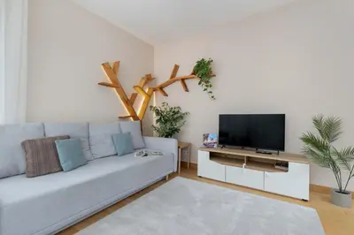 a living room with a couch and a flat screen tv at Family Apartment in Cracow with Parking, Desk and Bathtub by Noclegi Renters in Kraków