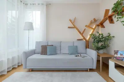 a living room with a blue couch in a room at Family Apartment in Cracow with Parking, Desk and Bathtub by Noclegi Renters in Kraków