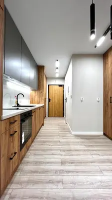a kitchen with wooden cabinets and a tile floor at Św Sebastiana 20 in Kraków