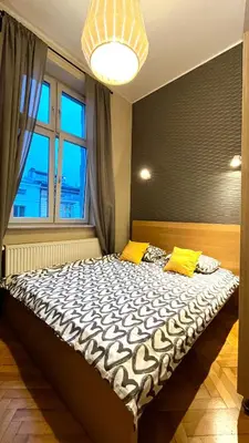 a large bed in a room with a large window at Św Sebastiana 20 in Kraków