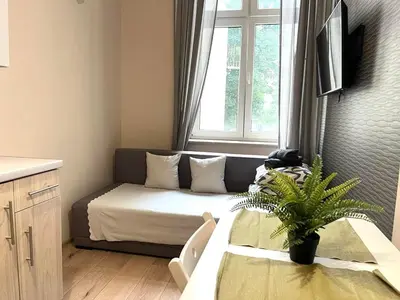 a small room with a bed and a window at Krakow Center Apartment in Kraków