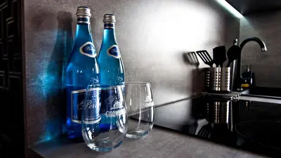two bottles and two glasses sitting on a counter at Apartament Mateo in Kraków