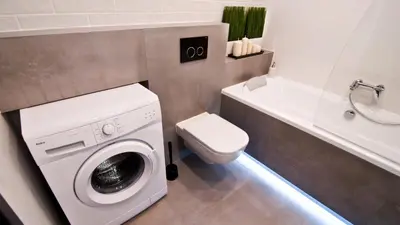 a bathroom with a washing machine and a toilet at Apartament Mateo in Kraków