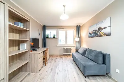 a living room with a couch and a television at RentPlanet - Apartament Olsza in Kraków