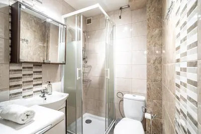 a bathroom with a toilet and a glass shower at RentPlanet - Apartament Olsza in Kraków