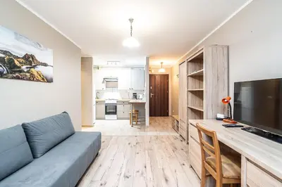 a living room with a couch and a flat screen tv at RentPlanet - Apartament Olsza in Kraków