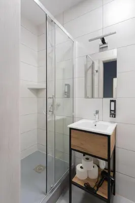 a white bathroom with a sink and a shower at SERENITY New Apartments Kraków in Kraków