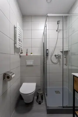 a bathroom with a toilet and a glass shower at SERENITY New Apartments Kraków in Kraków