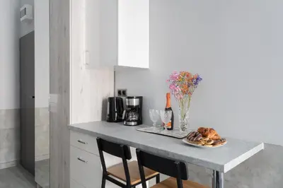a kitchen counter with a table with a plate of food at SERENITY New Apartments Kraków in Kraków