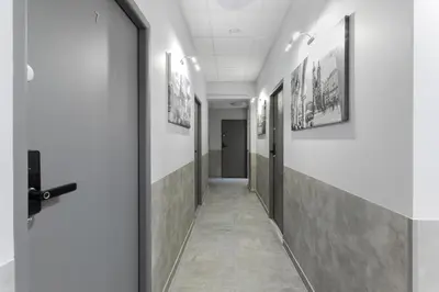 a corridor in a hospital with a door and pictures on the walls at SERENITY New Apartments Kraków in Kraków