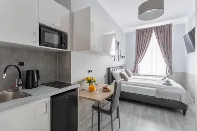 a kitchen with a bed and a table in a room at SERENITY New Apartments Kraków in Kraków