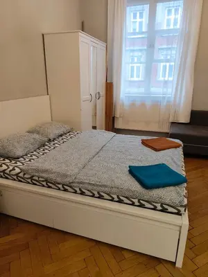 a bed in a room with a large window at Daniel Apart Hotel Krakow in Kraków