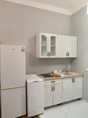 a kitchen with white cabinets and a white refrigerator at Daniel Apart Hotel Krakow in Kraków