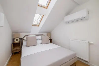 a small attic bedroom with a bed and two windows at 5 Bedroom apartment - Terrace, Jacuzzi, Sauna in Kraków