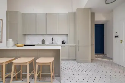 a kitchen with white cabinets and bar stools at 5 Bedroom apartment - Terrace, Jacuzzi, Sauna in Kraków