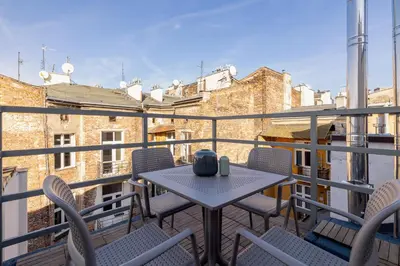 a patio with a table and chairs on a balcony at 5 Bedroom apartment - Terrace, Jacuzzi, Sauna in Kraków